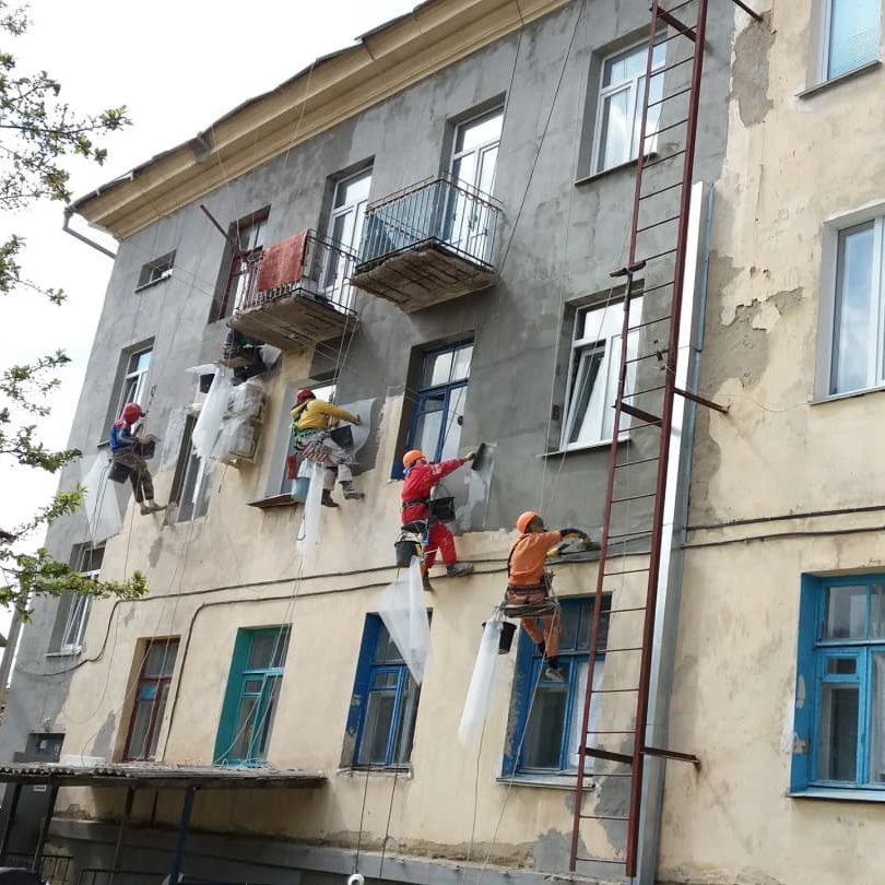 Промышленные альпинисты ремонтируют фасад многоквартирного дома